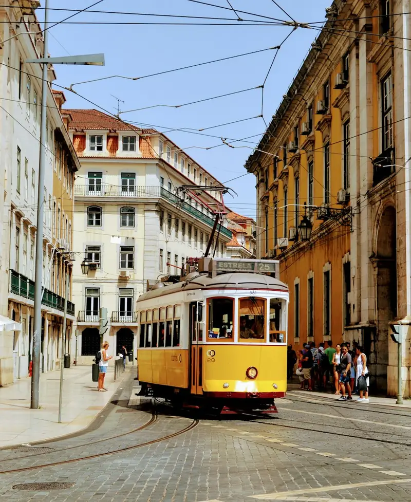 Gelbe Straßenbahn in einer Altstadtgasse von Lissabon